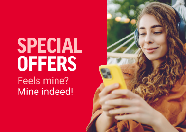 Woman with headphones sitting outside in hammock, checking her phone. 