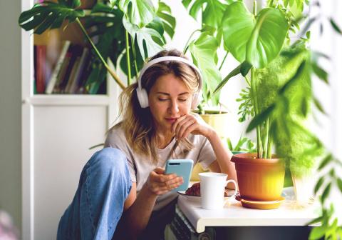 Мужчина наслаждается кофе у себя дома, глядя в свой ноутбук. 